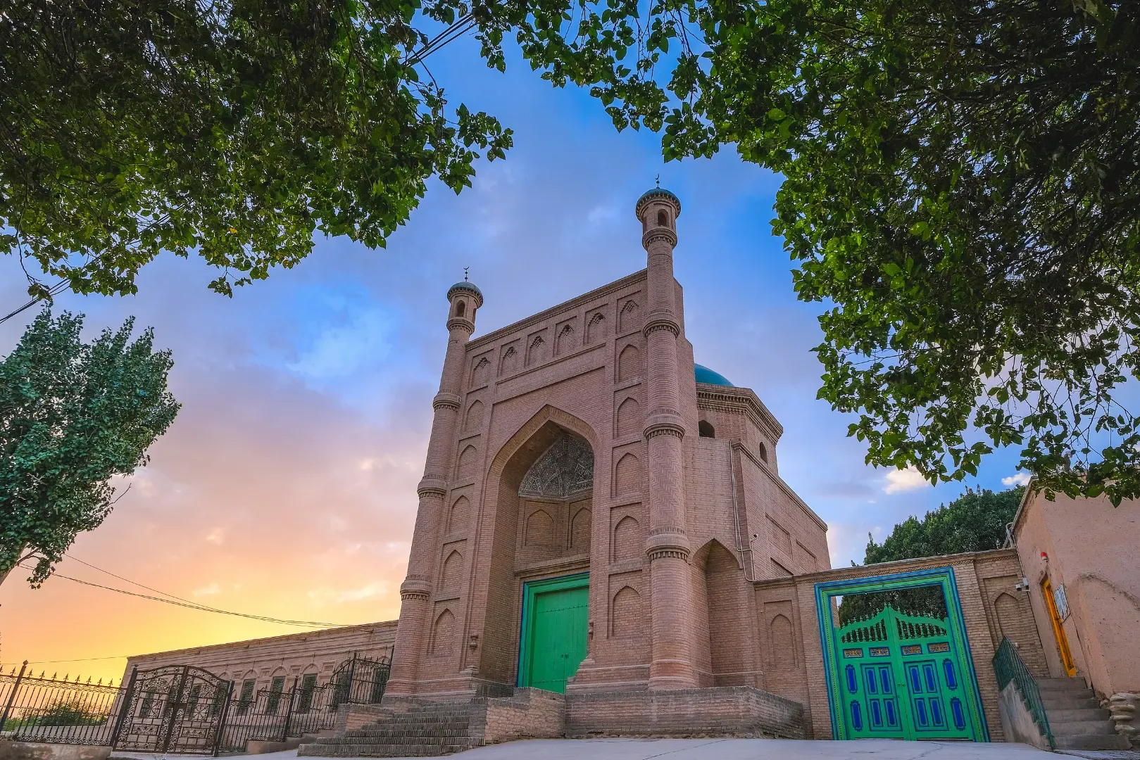 Kuqa Grand Mosque main gate at sunset with trees